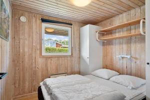 a bedroom with a bed in a wooden wall at SJ310-Hejls-Ronnebaervaenget-14 in Hejls
