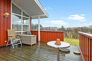 a porch of a house with a table on a deck at LN1971-Lonstrup-Kirkedalsvej-7 in Lønstrup