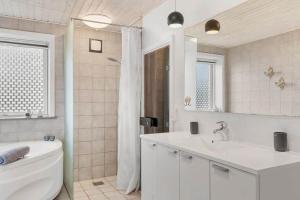 a bathroom with a tub and a sink and a toilet at SJ311-Hejls-Slaenvaenget-9 in Hejls +22 photos
