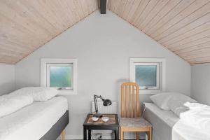 a bedroom with two beds and a table with a chair at SJ311-Hejls-Slaenvaenget-9 in Hejls