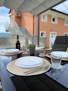 a table with plates and glasses and a bottle of wine at Apartment Aurora in Ankaran