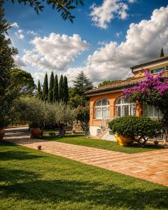 a house with a garden with purple flowers at Villa Silvio Relais in Civitanova Alta