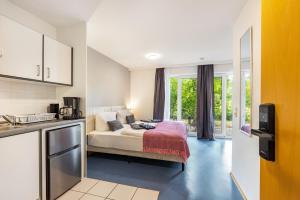 a bedroom with a bed in a room with a kitchen at Terrasse Double Studio Apartments in Lübeck