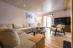 a living room with a couch and a tv at Renovated Triplex House 8 guests Orelle in Orelle
