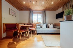 a living room with a table and a couch at Faneskla Apartments in Silbertal