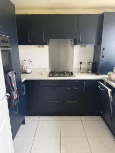 a kitchen with black cabinets and white tile floors at The Pentland Escape in Roslin