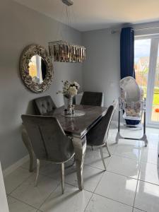 a dining room with a table and chairs and a mirror at The Pentland Escape in Roslin