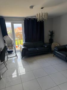 a living room with a couch and a chandelier at The Pentland Escape in Roslin