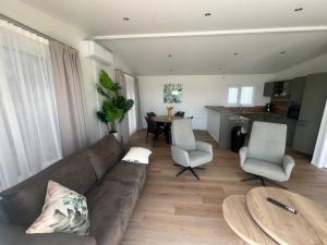 a living room with a couch and chairs and a table at Green Flower in Renesse