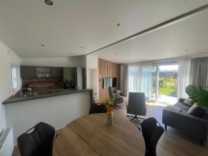 a living room with a wooden table and a kitchen at Green Flower in Renesse