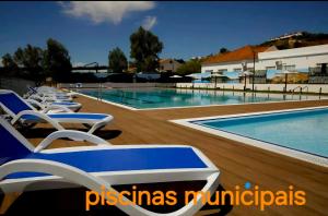 a swimming pool with chaise lounge chairs and a swimming pool at Casa da Avenida in Mértola
