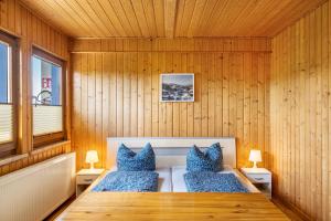 a sauna with blue pillows and a wooden wall at Bergpanorama Ruhla in Ruhla