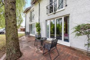 a patio with a table and chairs next to a tree at Terrasse Double Studio Apartments in Lübeck
