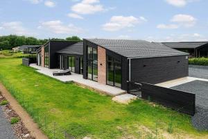 a black house with a green lawn in front of it at SJ313-Borkop-Sommerhaven-38 in Mørkholt