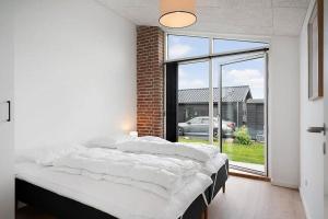 a large bed in a room with a large window at SJ313-Borkop-Sommerhaven-38 in Mørkholt