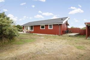 a red house with a bench and a fence at LN76740-Hjorring-Sostjernevej-11 in Hjørring