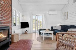 a living room with a couch and a fireplace at LN1883-Hjorring-Revlingrenden-13 in Hjørring