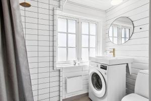 a white bathroom with a washing machine and a sink at LN1883-Hjorring-Revlingrenden-13 in Hjørring +15 photos