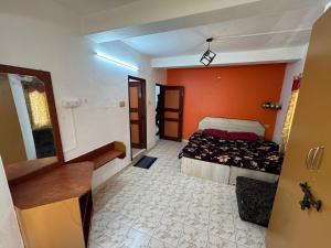 a bedroom with two beds and an orange wall at DD cottages in Ooty