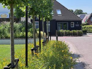 a row of trees in front of a building at BrinkZicht vakantieverblijf in Peize