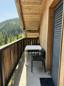a wooden balcony with a table and chairs on it at Otta Apartments Golte in Mozirje