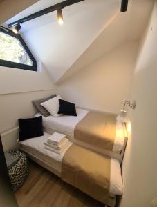 two beds in a small room with a window at Otta Apartments Golte in Mozirje
