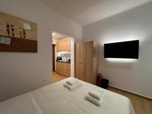 a bedroom with a bed and a flat screen tv at Prime 27 Luxury Studio in Lavrio