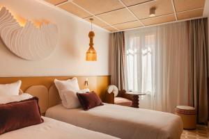 a hotel room with two beds and a window at Posidonia Hôtel in Nice +26 photos