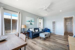 a living room with a blue couch and a table at Oceanfront unit, Private Balcony, Beach Access, Sunset Views in Carlsbad
