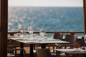 a row of wine glasses on tables in a restaurant at Baya Hotel in Capbreton