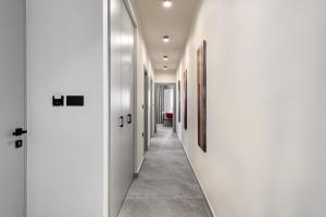 a corridor of a hallway with white walls and tile floors at Costa Blu Mare in Haraki +30 photos