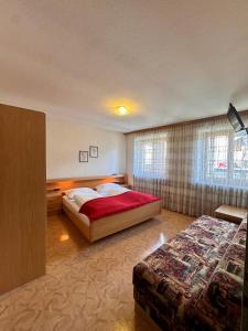a hotel room with two beds and a window at Hotel Goldenes Kreuz - since 1605 in Vipiteno