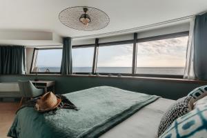 a bedroom with a bed with a hat on it at Baya Hotel in Capbreton