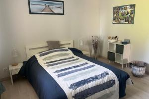 a bedroom with a bed with a blue and white blanket at Maison avec jardin & proche plages in Saint-Jean-de-Védas