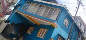 a blue building with windows on a street at DD cottages in Ooty