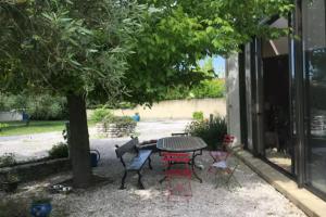 a patio with a table and chairs under a tree at Maison avec jardin & proche plages in Saint-Jean-de-Védas