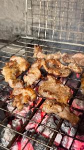 a bunch of food is cooking on a grill at - Cemi Rooms - River View & Traditional Restaurant in Tamarë