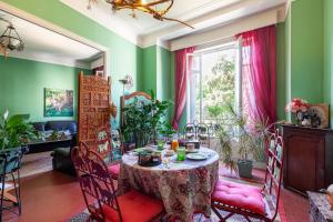 a dining room with a table and pink chairs at Chambres D'hôtes Chez Marie in Marseille +12 photos