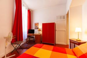 a bedroom with a colorful bed and a red cabinet at Chambres D'hôtes Chez Marie in Marseille