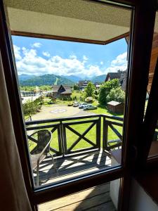 a view from a window of a balcony with a chair at Willa Regina II Resort & SPA in Zakopane +90 photos