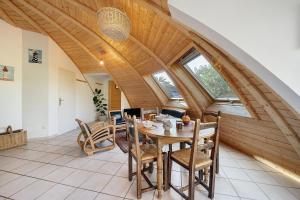 a dining room with a wooden ceiling and a table and chairs at Les Dômes Du Ponant in Plouguerneau +17 photos