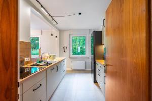 a kitchen with white cabinets and a large window at Schillings Häusken in Brilon