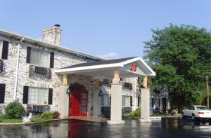 un edificio con una puerta roja y un coche delante en Ripon Welcome Inn and Suites en Ripon