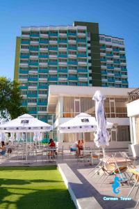 a hotel with chairs and umbrellas and a building at Hotel Carmen Tower - Balada in Saturn