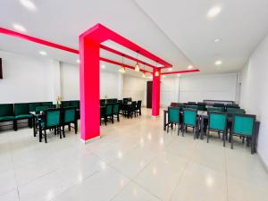 a dining room with tables and chairs and red beams at Matha Residency in Kasauli