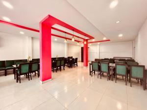 a dining room with tables and chairs and red beams at Matha Residency in Kasauli