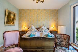 a bedroom with a bed with two chairs and a window at Schillings Häusken in Brilon