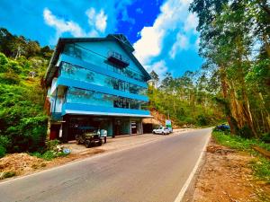 a blue building on the side of a road at Matha Residency in Kasauli