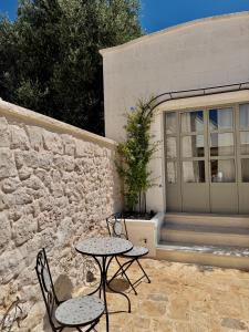 a patio with two tables and chairs in front of a building at Trullo botanico in Ceglie Messapica