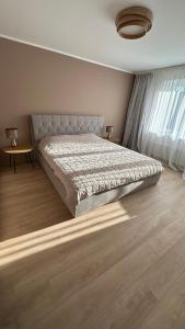 a bedroom with a bed and a table and a window at Peaceful haven in Liepāja